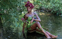 a woman in a green dress sitting in a river